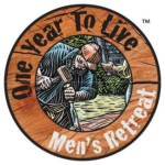 Circular logo; outer ring is a wood-colored background with the text "One Year To Live" in black and "Men's Retreat" in white; inner circle has a drawing of white man in a denim shirt and orange baseball cap working with a chisel and hammer. He is outdoors.