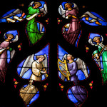 [Image description: Stained glass window with images of angels.]