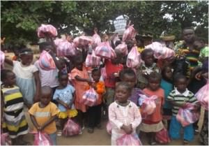 Children in the Sierra Leone community of Krissy Town hold up their bags of take-away food, after one of the wet feeding programs.