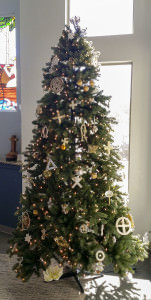 [Image description: a tall Christmas tree decorated with white and gold Chrismon ornaments]