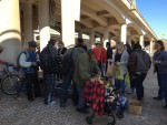 [Image description: a group of people from diverse backgrounds gather under the overpass bridge of the I-35 highway in Waco.]